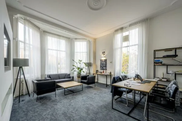 Modern ingericht kantoor met zithoek en grote ramen aan de Van Eedenstraat.